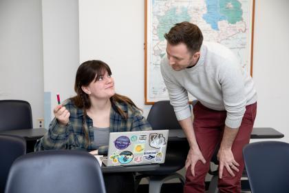 Teacher giving feedback to a student in the classroom.