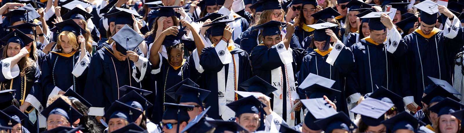 Longwood graduates adjust their caps and tassels during Commencement.