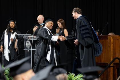 Graduate shaking hands with President Reveley at 2025 Graduate Ceremony