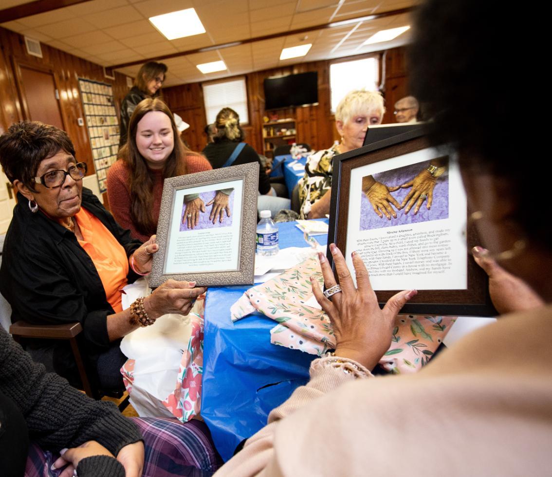 Students work with older adults on a project they created for them.