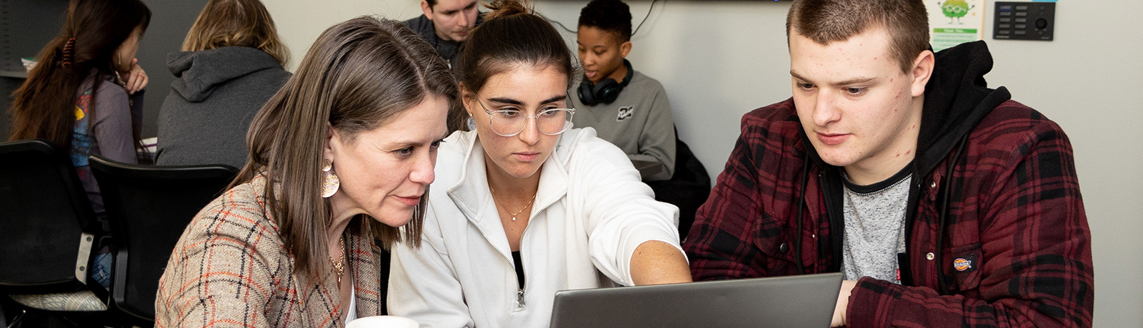 Longwood University students and a faculty member collaborating around a laptop