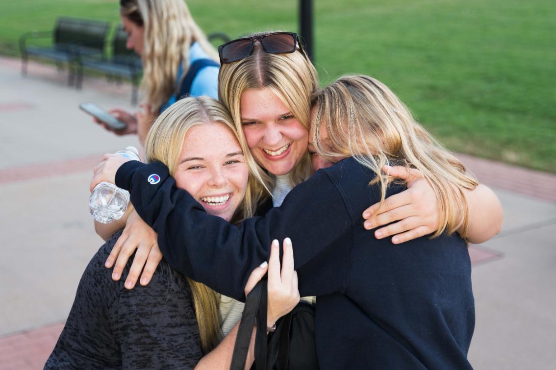 Three students hugging during New Lancer Days