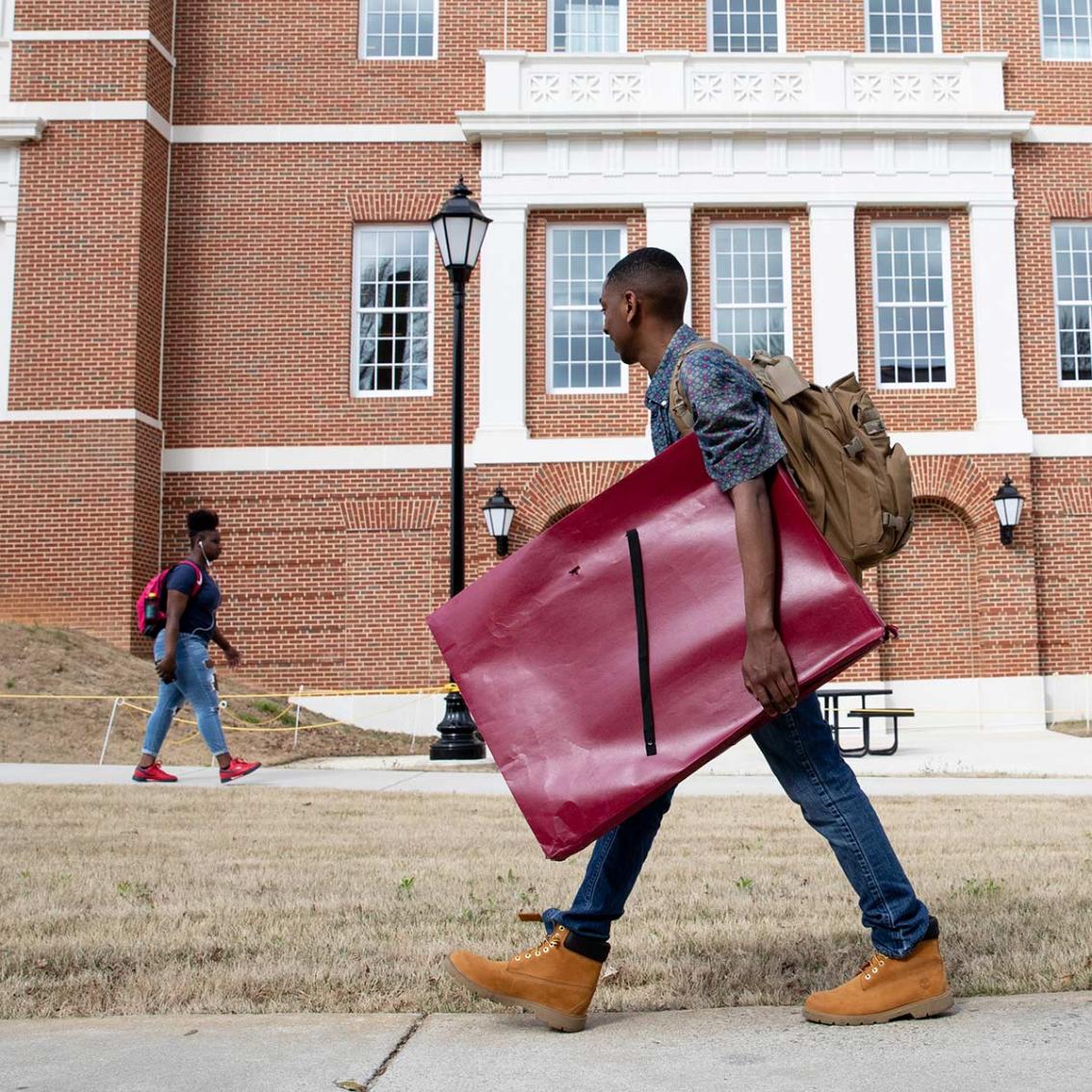 Art portfolios can be awkward to carry across campus, but seeing friends makes it easier.