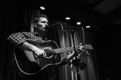 Brayden Mullins playing guitar and singing on stage