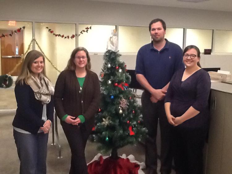 IT Department standing by a Christmas tree