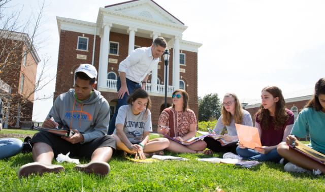 Students working with a professor outside Grainger