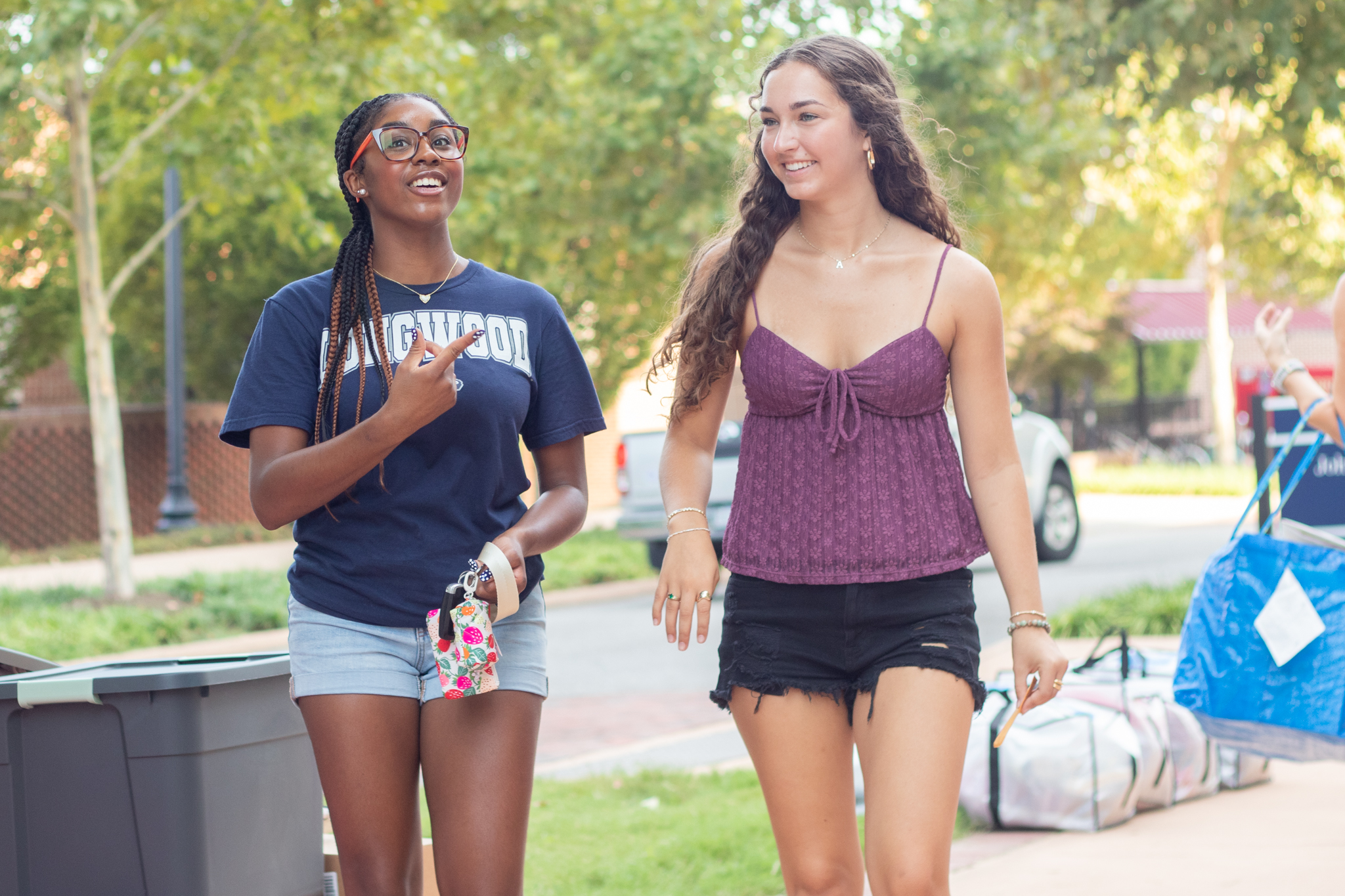 Two freshmen students walk together in front of Moss and Johns Halls during move-in.