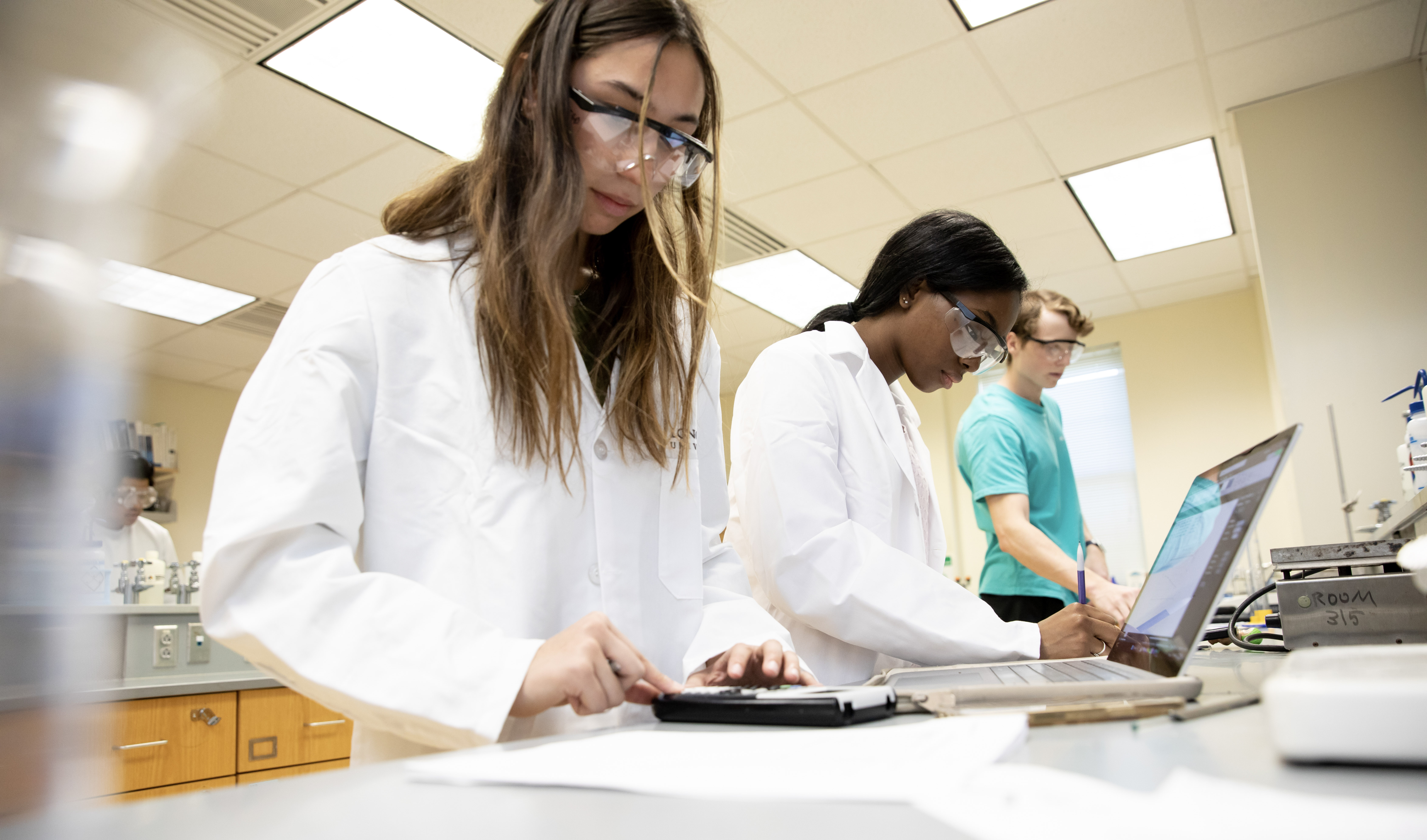 Three students study in a chemistry lab